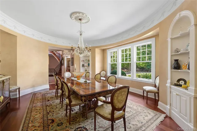 a dining room with furniture a chandelier and wooden floor