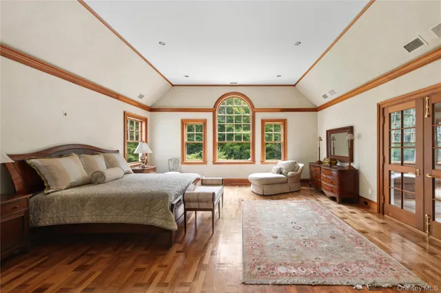 a bedroom with a bed and large windows