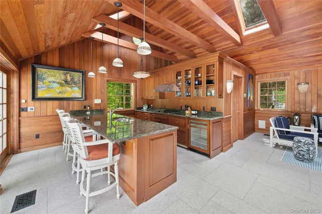 a kitchen with stainless steel appliances kitchen island granite countertop a table and chairs in it