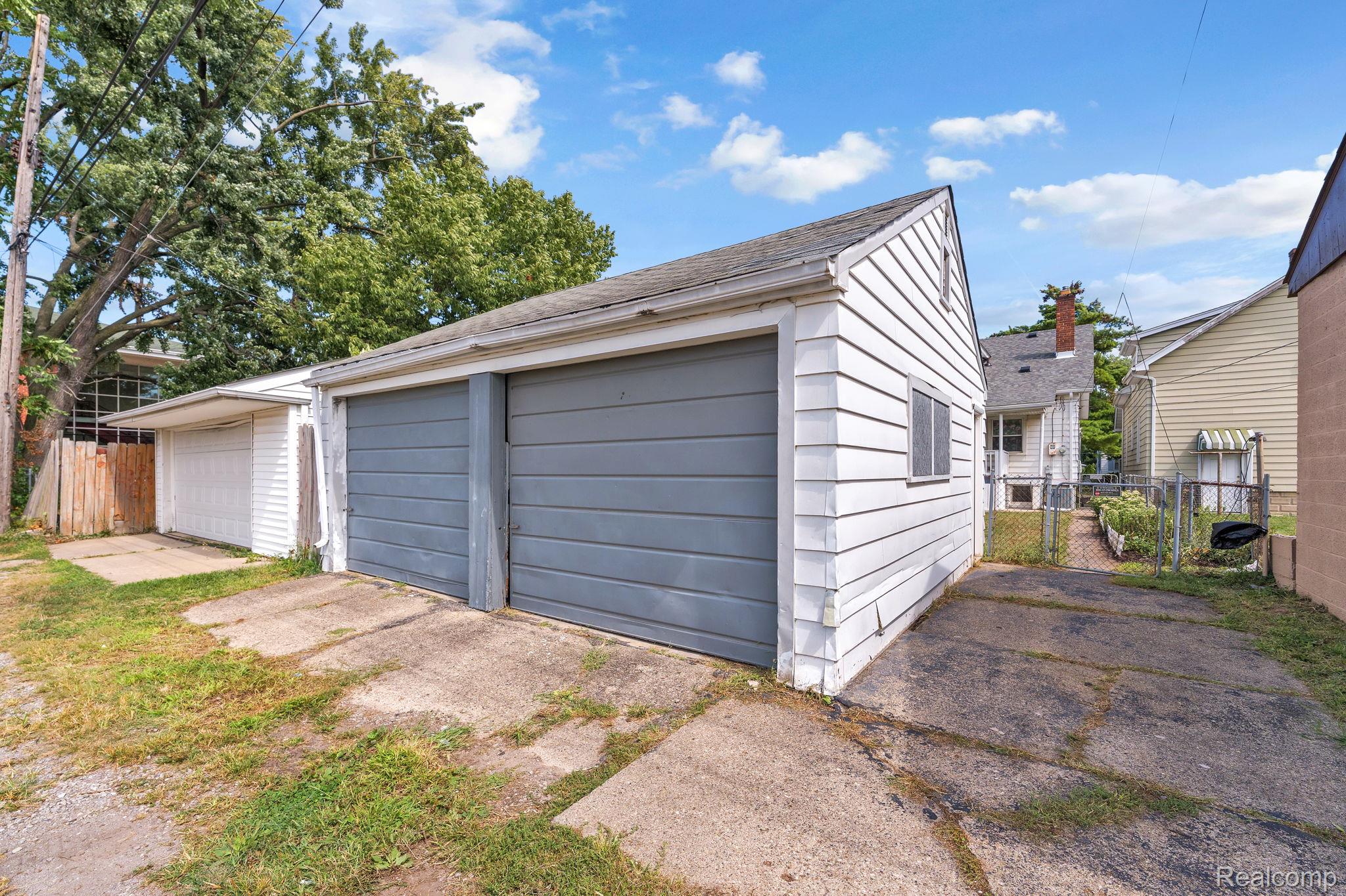7631 Maple Street Dearborn, MI 48126 - Photo 45 of 48 Detached garage with two bays, white siding, and gray garage doors