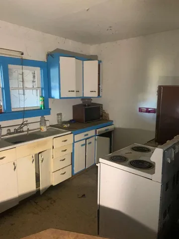 a kitchen with cabinets appliances a sink and a window