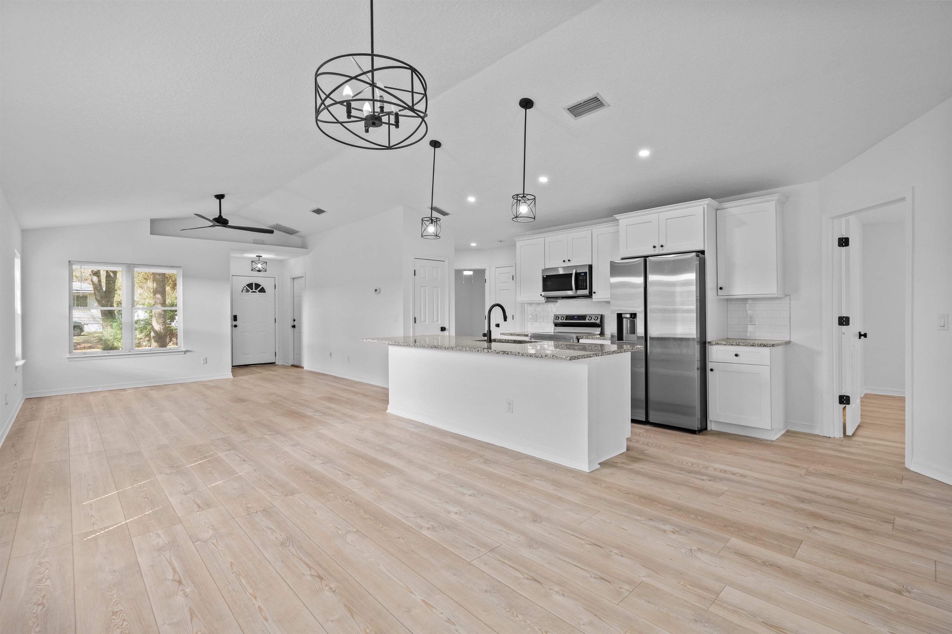 236 Nesmith Avenue St. Augustine, FL 32084 - Photo 16 of 40 a large white kitchen with kitchen island a stove a sink dishwasher a refrigerator and white cabinets with wooden floor
