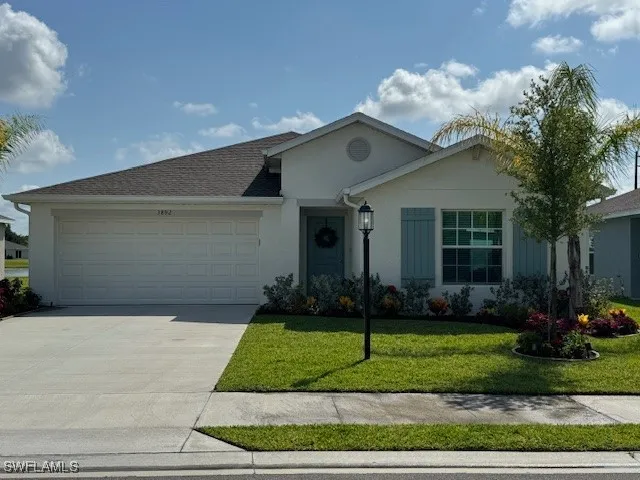 a front view of a house with a garden and plants