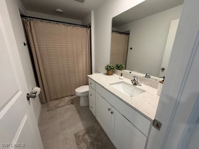 a bathroom with a sink a toilet a mirror and shower