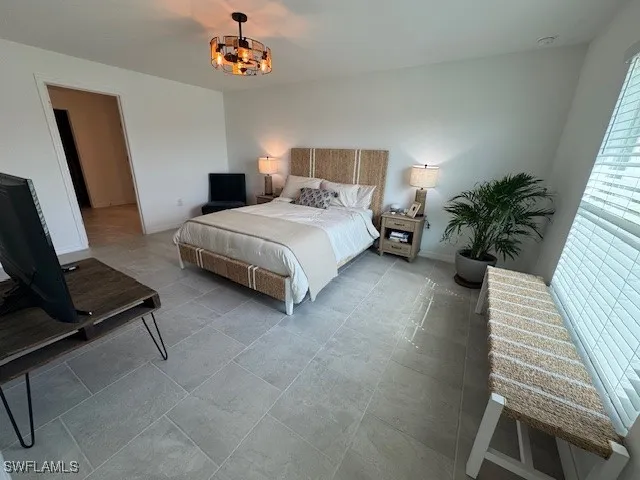 a bedroom with a bed window and potted plant