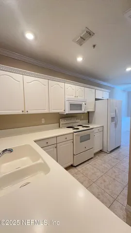 a kitchen with white cabinets and white appliances