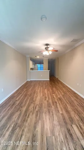 a view of empty room with wooden floor