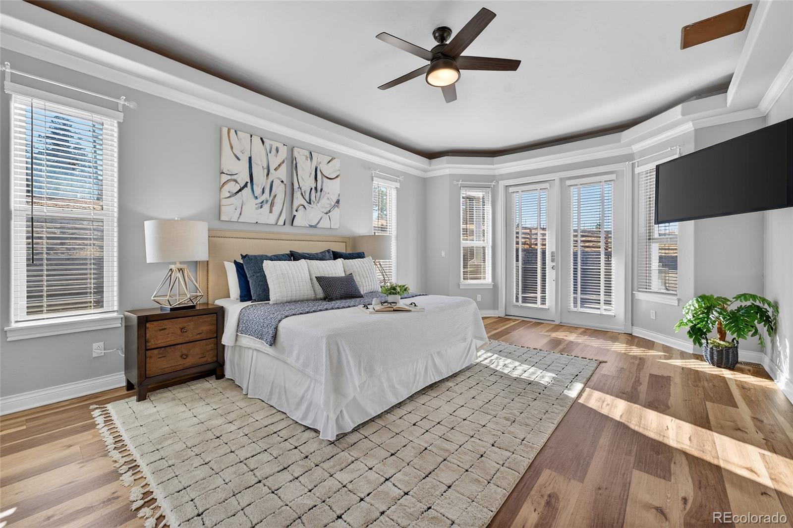 575 Howling Circle Elizabeth, CO 80107 - Photo 15 of 48 a spacious bedroom with a large bed a chandelier and windows