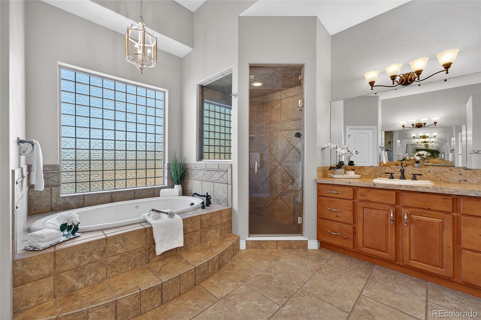 575 Howling Circle Elizabeth, CO 80107 - Photo 16 of 48 a bathroom with a tub sink and mirror