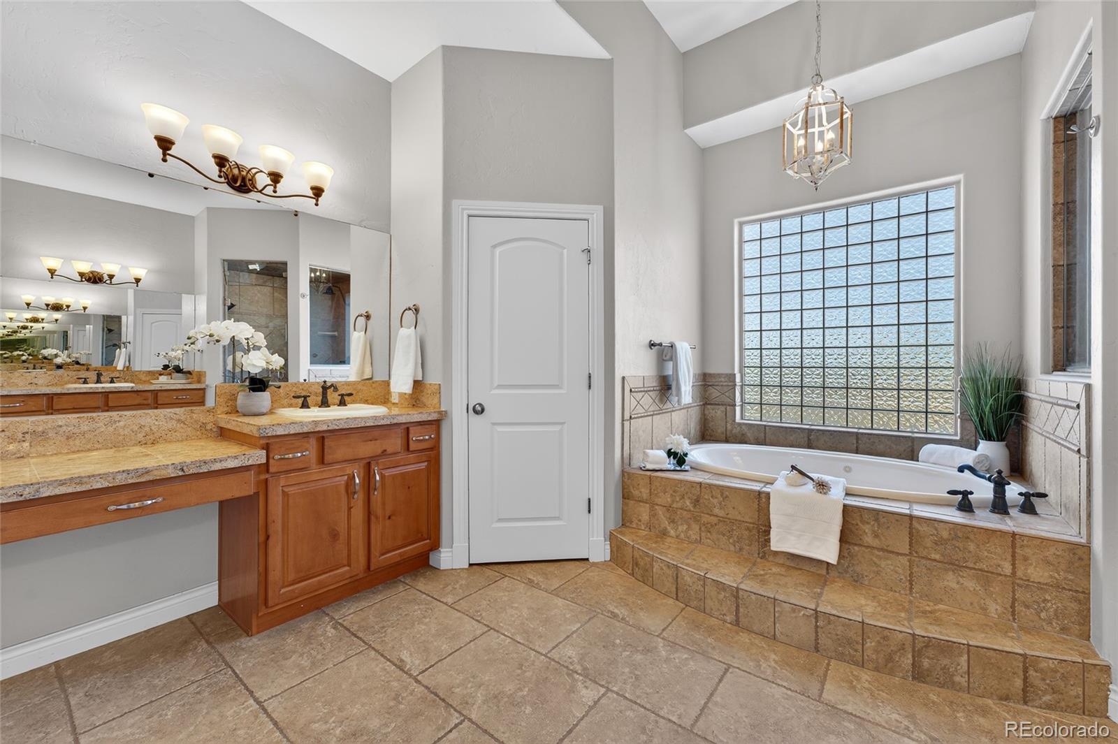 575 Howling Circle Elizabeth, CO 80107 - Photo 18 of 48 a spacious bathroom with a double vanity sink a mirror and a bathtub