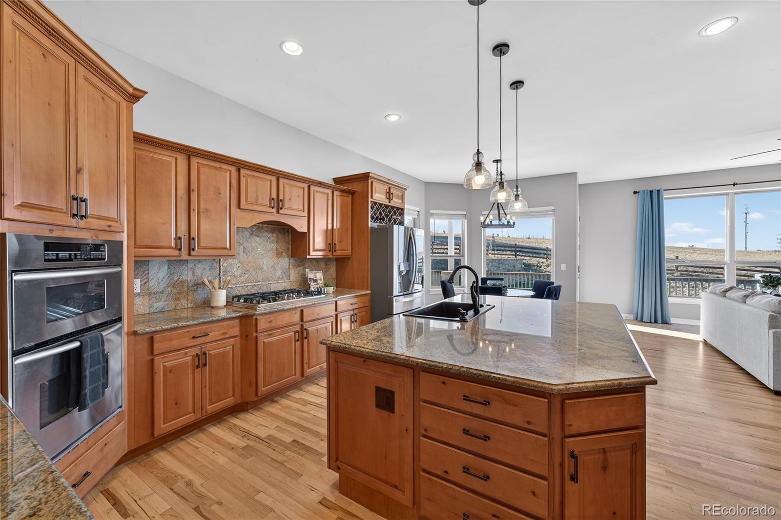 575 Howling Circle Elizabeth, CO 80107 - Photo 21 of 48 a kitchen with kitchen island granite countertop a sink stainless steel appliances and cabinets