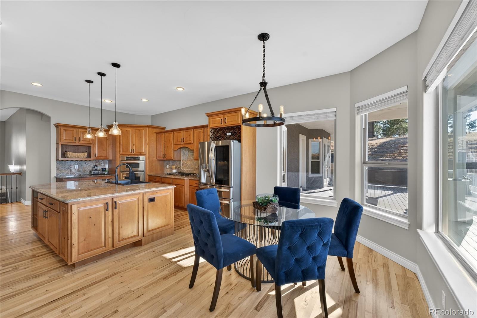 575 Howling Circle Elizabeth, CO 80107 - Photo 22 of 48 a kitchen with stainless steel appliances a dining table chairs and white cabinets
