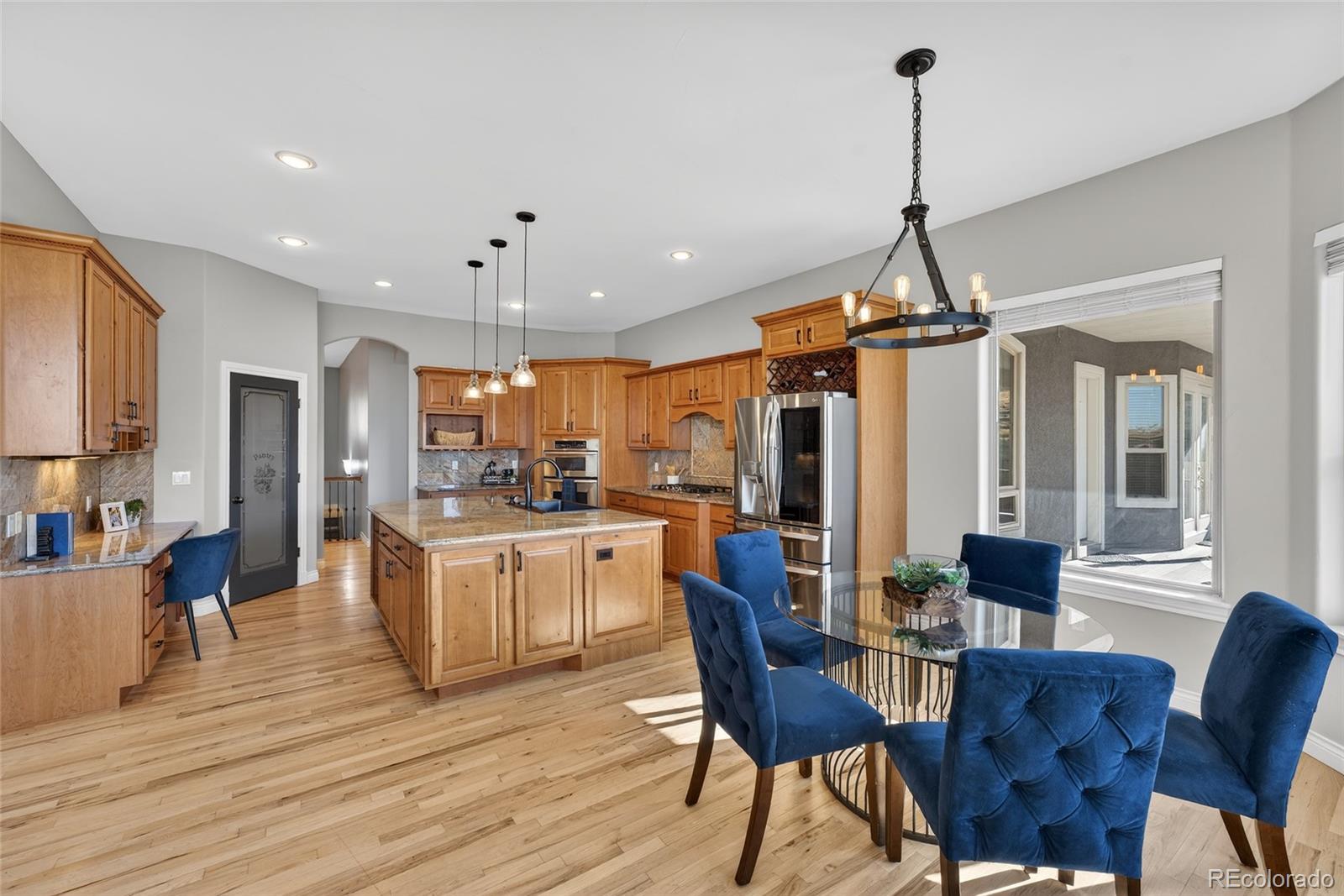 575 Howling Circle Elizabeth, CO 80107 - Photo 23 of 48 a view of a dining room and livingroom with furniture wooden floor a chandelier