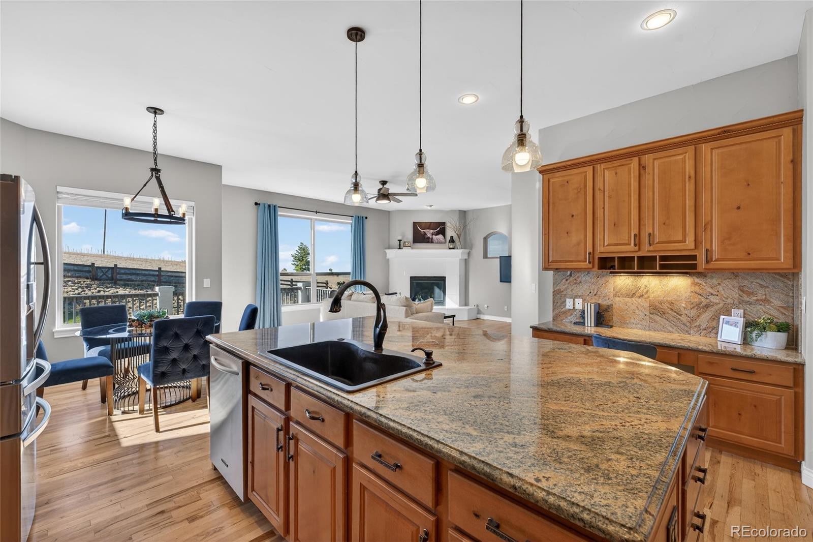 575 Howling Circle Elizabeth, CO 80107 - Photo 27 of 48 a kitchen with stainless steel appliances granite countertop a sink a stove and a wooden floors