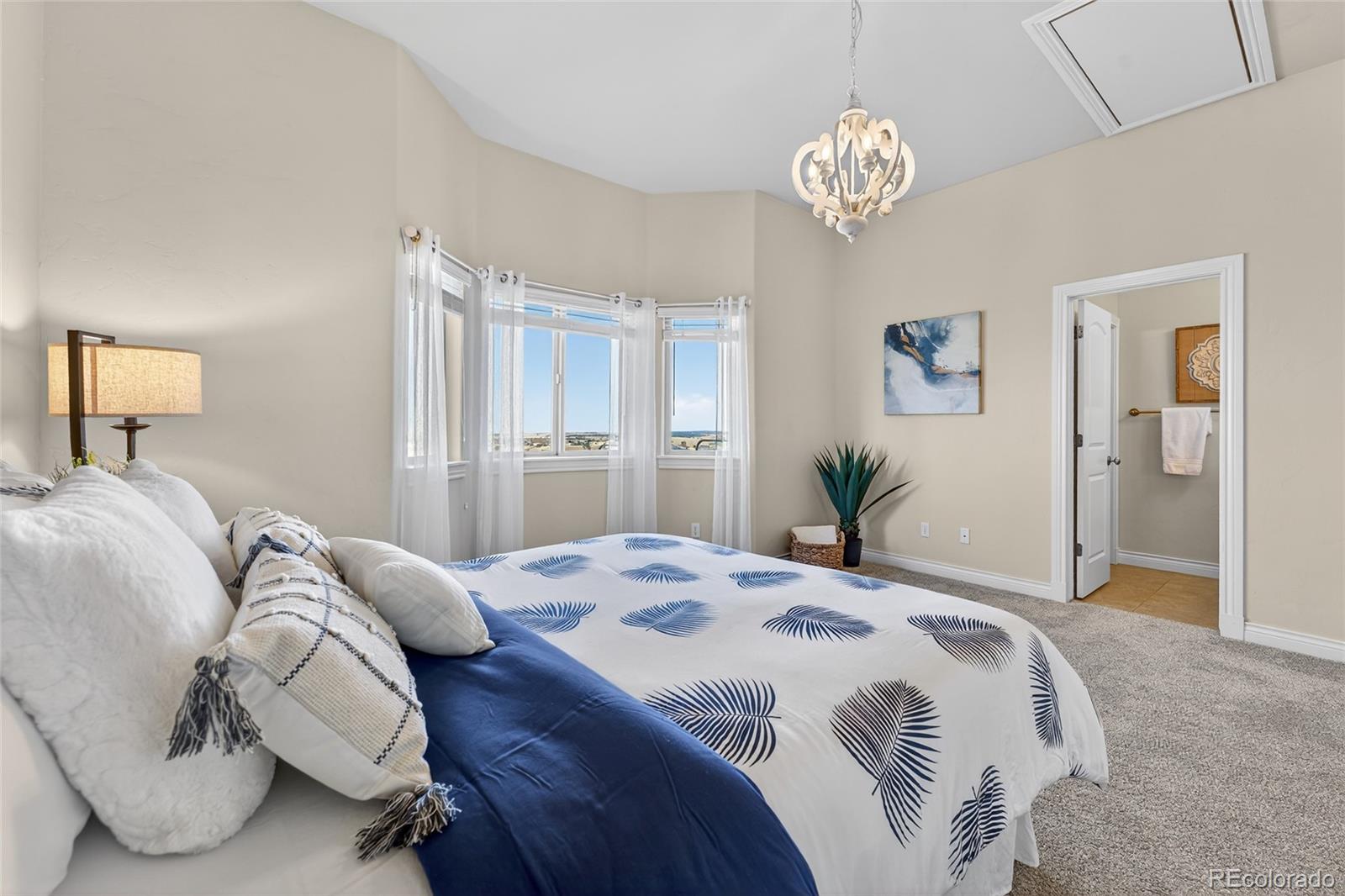 575 Howling Circle Elizabeth, CO 80107 - Photo 31 of 48 a bedroom with a bed and a chandelier