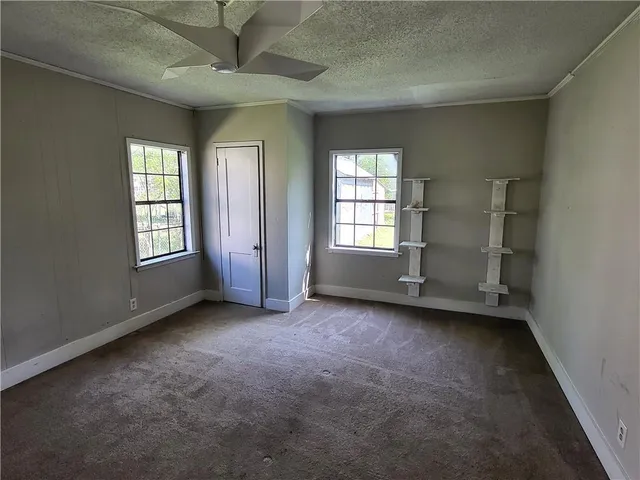 an empty room with windows and closet in a room