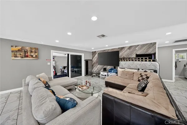 a kitchen with stainless steel appliances kitchen island granite countertop a refrigerator a stove a sink dishwasher and white cabinets with wooden floor