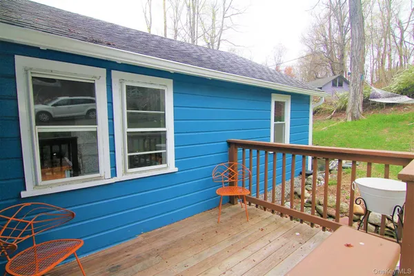 a view of a deck with two chair and a floor to ceiling window