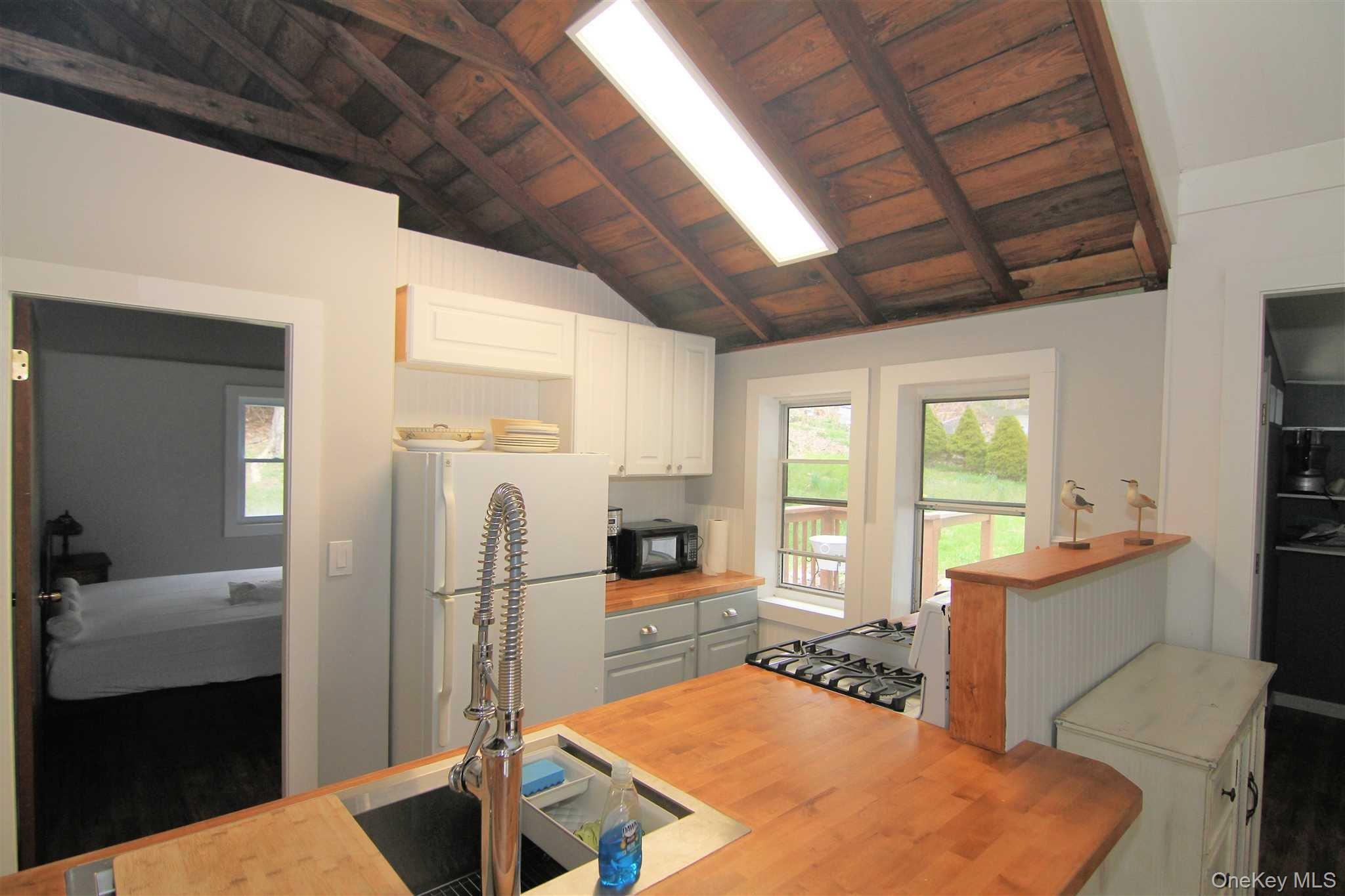 71 Miller Road, Unit 12 Hopewell Junction, NY 12533 - Photo 10 of 31 a kitchen with stainless steel appliances granite countertop a refrigerator a sink dishwasher a stove and a dining table with wooden floor