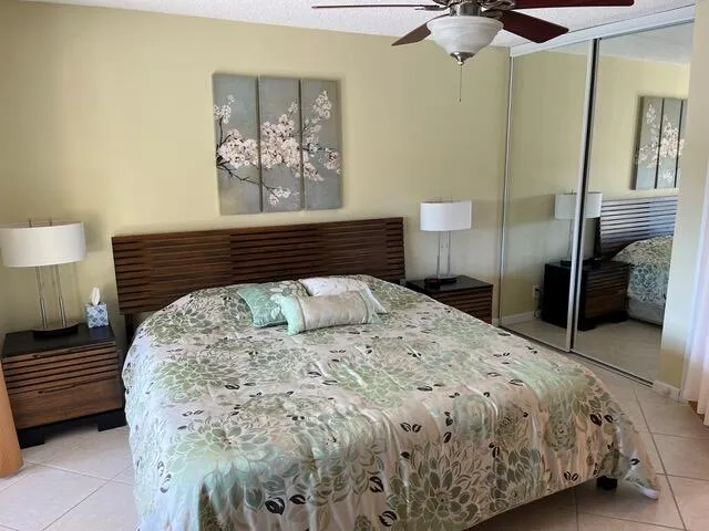 a bedroom with a bed and a lamp on dresser