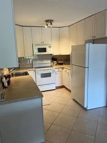 a kitchen with kitchen island a counter top space appliances and cabinets