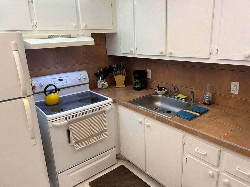 59 Tilford C, Unit 59 Deerfield Beach, FL 33442 - Photo 2 of 39 a kitchen with a sink and cabinets