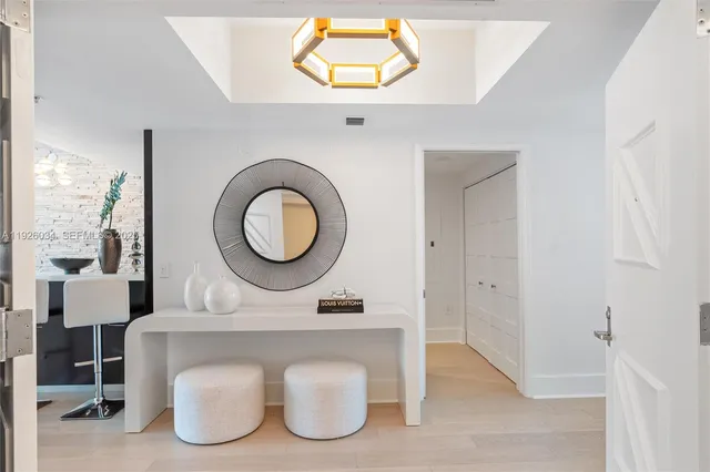 a living room with furniture a chandelier and a dining table