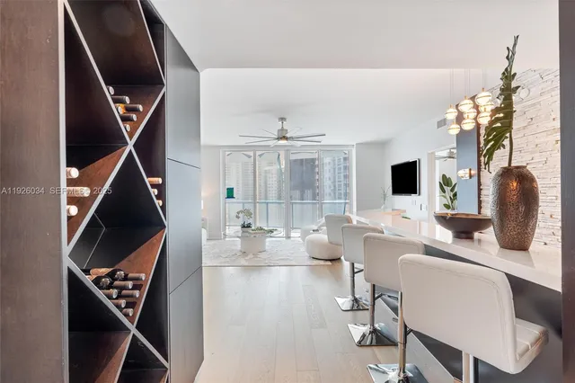 a living room with furniture a large window and wooden floor