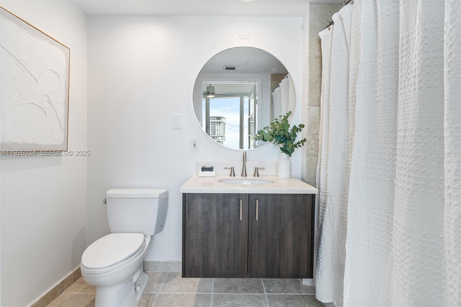 333 Las Olas Way, Unit 2406 Fort Lauderdale, FL 33301 - Photo 31 of 55 a bathroom with a toilet sink and mirror