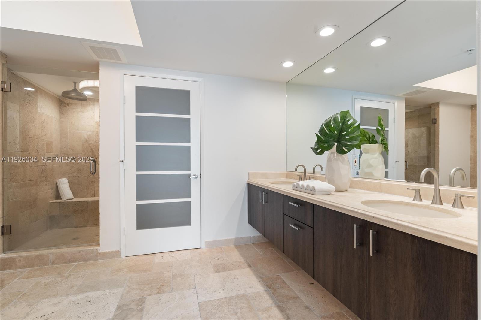 333 Las Olas Way, Unit 2406 Fort Lauderdale, FL 33301 - Photo 38 of 55 a spacious bathroom with a double vanity sink a mirror and a shower