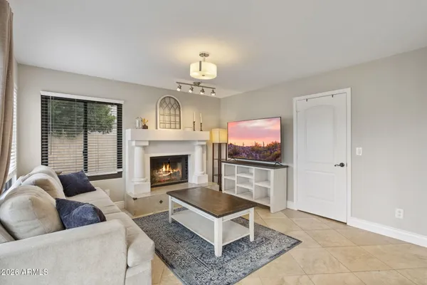 a living room with furniture a flat screen tv and a fireplace