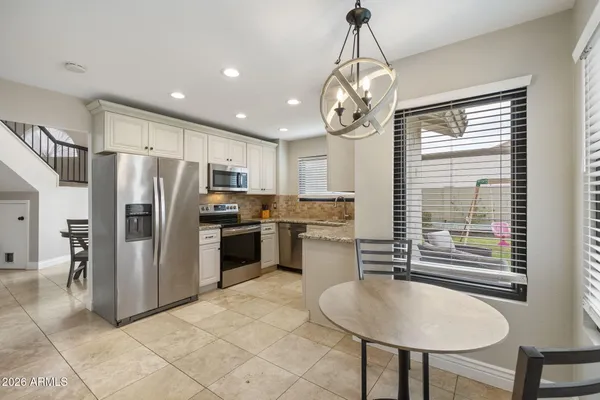 a kitchen with refrigerator a sink cabinets and wooden floor