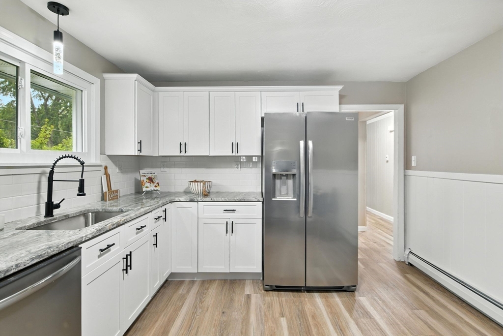 17 Pebble Mill Road Springfield, MA 01118 - Photo 12 of 30 a kitchen with stainless steel appliances granite countertop a refrigerator a sink and white cabinets with wooden floor