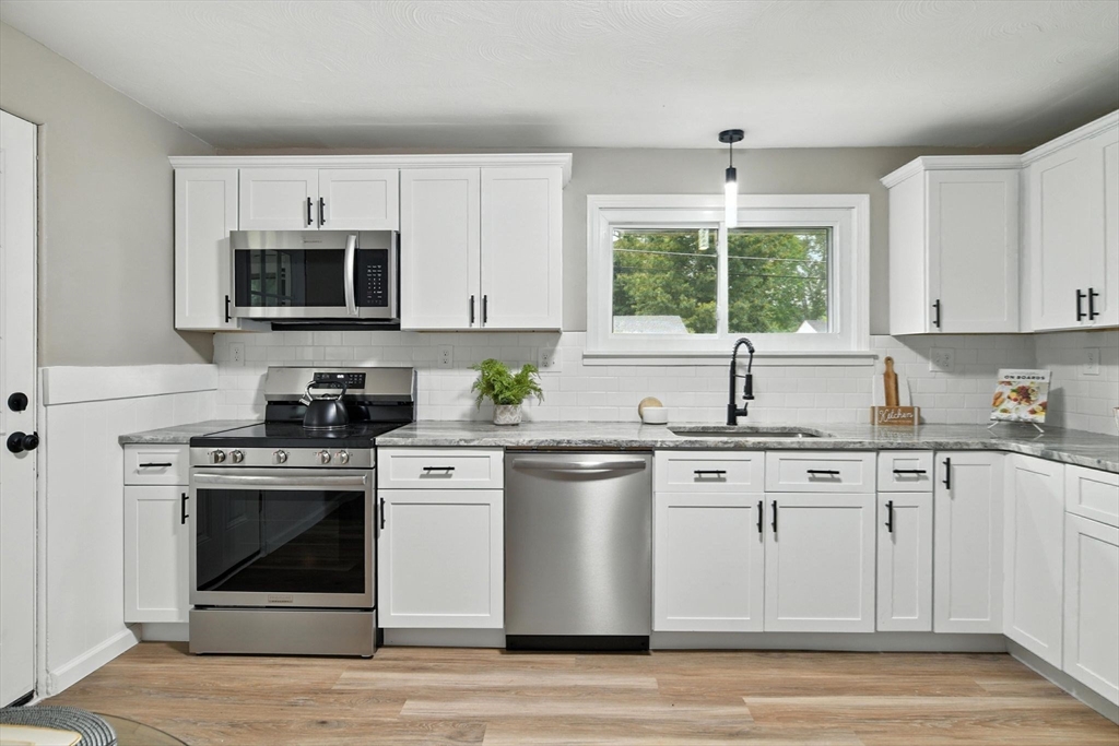 17 Pebble Mill Road Springfield, MA 01118 - Photo 10 of 30 a kitchen with stainless steel appliances granite countertop a stove a sink and a microwave