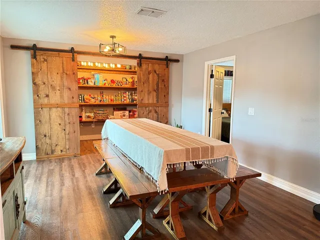 a dining room with furniture and wooden floor