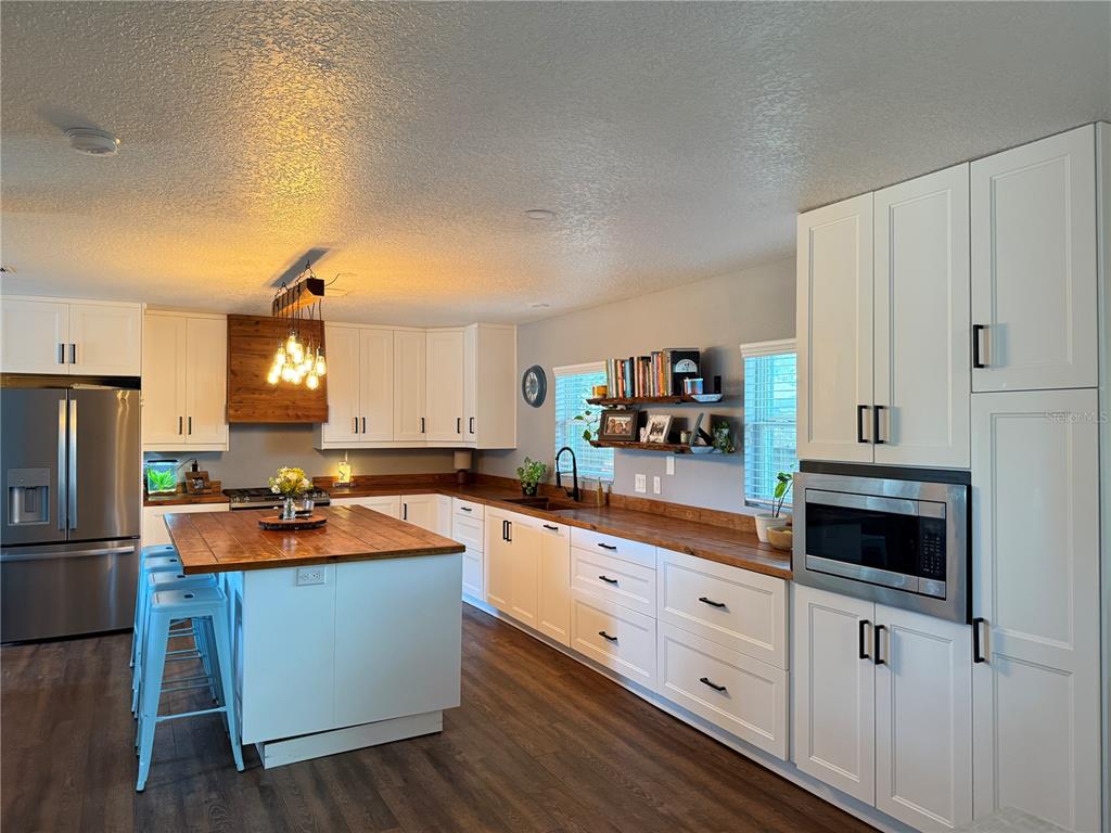 10056 Gifford Drive Spring Hill, FL 34608 - Photo 6 of 27 a kitchen with granite countertop a sink stove and cabinets