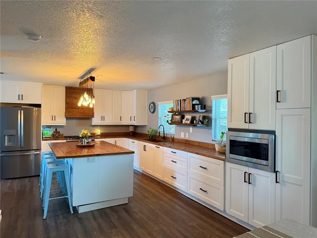 a kitchen with stainless steel appliances a stove refrigerator sink and cabinets