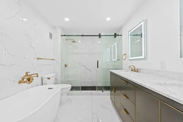 a bathroom with a tub sink and mirror