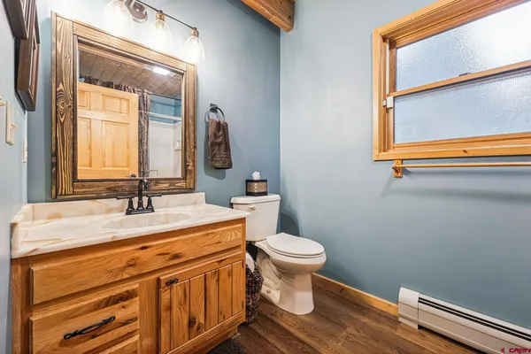 a bathroom with a granite countertop sink mirror vanity and toilet