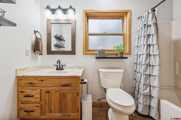 a bathroom with a granite countertop toilet sink and mirror
