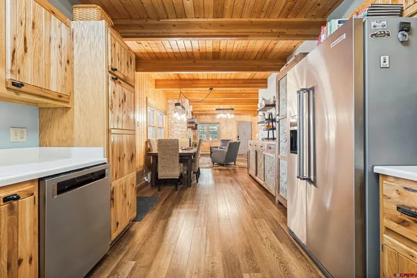 a view of a hallway with wooden floor and furniture