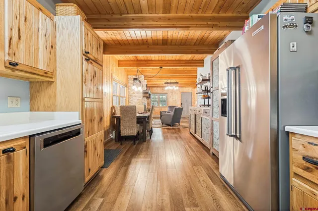 a view of a hallway with wooden floor and furniture