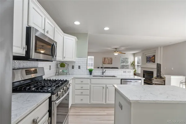 a kitchen with stainless steel appliances granite countertop a sink stove microwave and cabinets