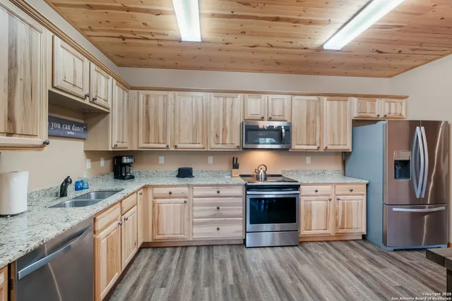 a kitchen with stainless steel appliances granite countertop a stove a sink dishwasher and a refrigerator