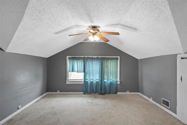 en empty room with windows and fan