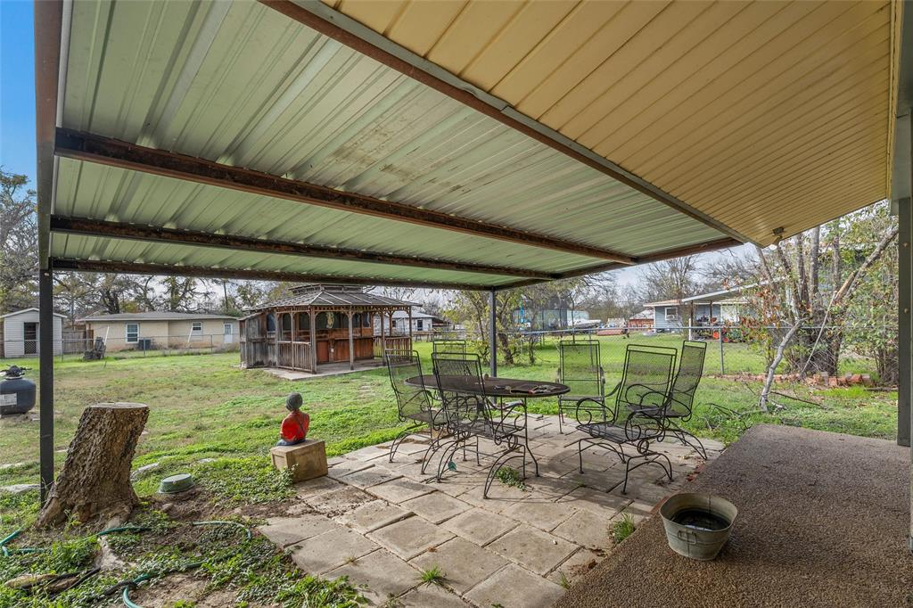 306 South Cleveland Meridian, TX 76665 - Photo 21 of 26 a backyard of a house with table and chairs