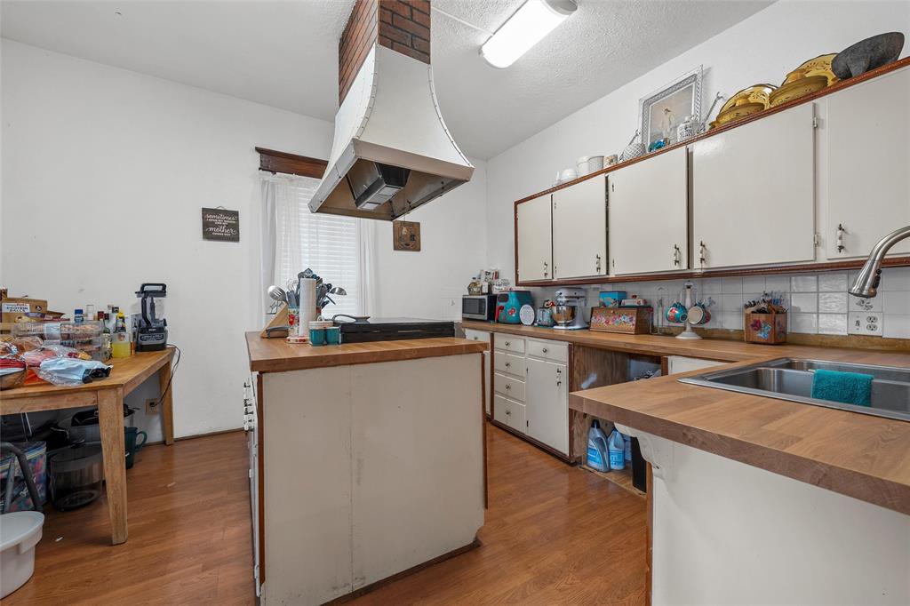 306 South Cleveland Meridian, TX 76665 - Photo 9 of 26 a kitchen with cabinets a sink and appliances