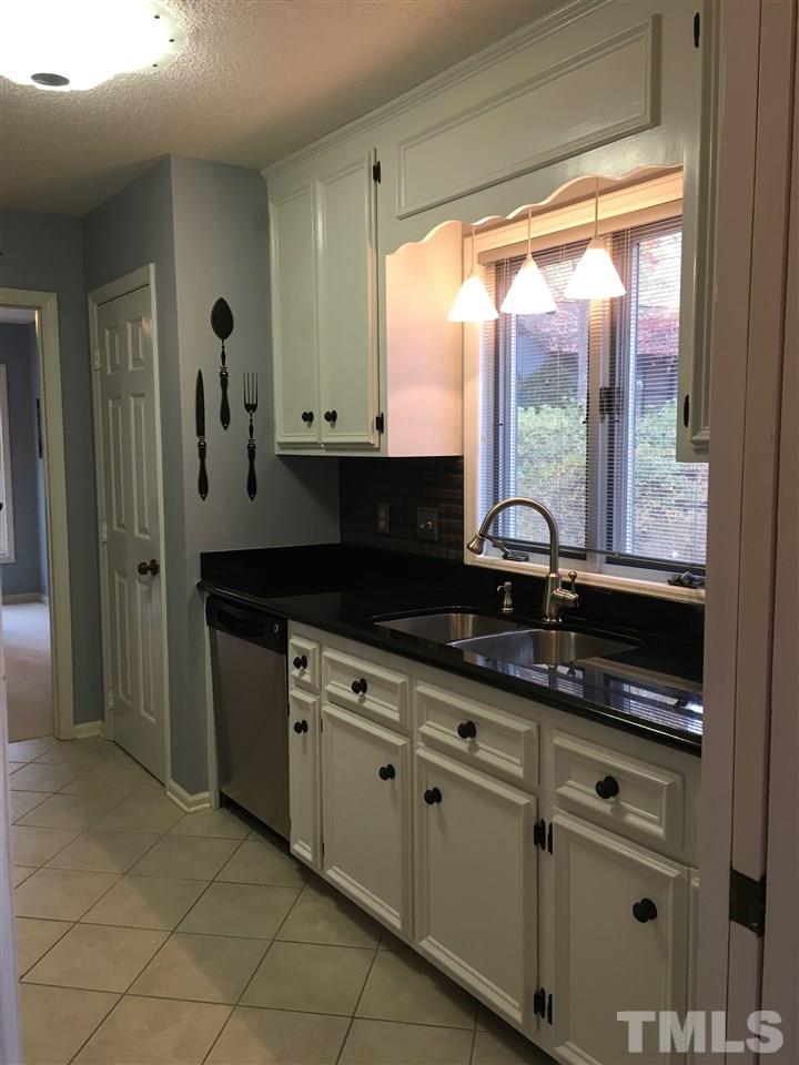 2850 Rue Sans Famille Raleigh, NC 27607 - Photo 8 of 24 a kitchen with granite countertop a sink and a white wooden cabinets