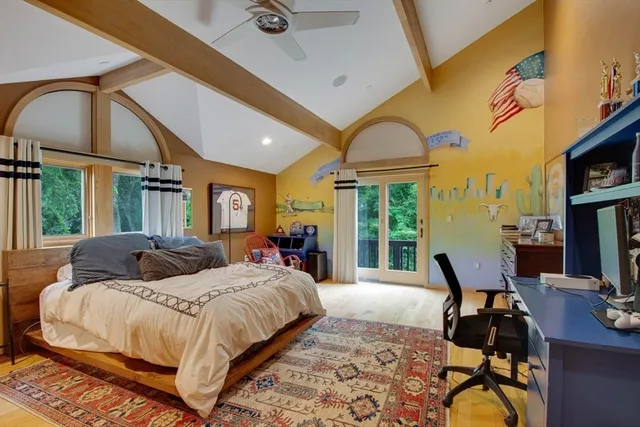 a spacious bedroom with a bed a table and large windows