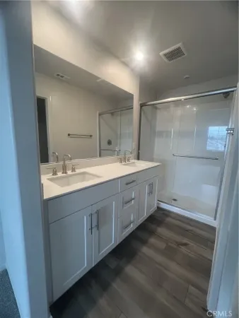 a bathroom with a double vanity sink a mirror and a shower